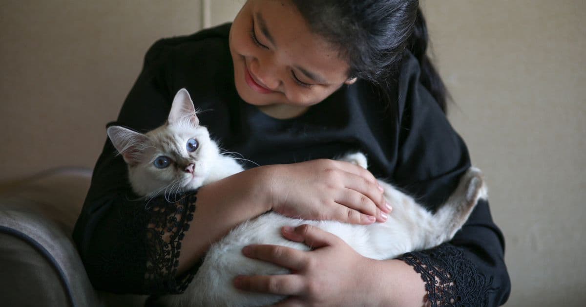 Woman lovingly holding her cat - Petmeetly community member